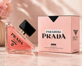 Prada Paradoxe Intense Eau de Parfum bottle next to its pink packaging box on a light marble surface with soft shadows.