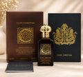 A bottle of Clive Christian Private Collection Woody Leather perfume spray stands in front of its brown box and a black presentation box with gold crest, on a light beige surface with a soft neutral background.