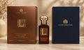 Clive Christian Private Collection L Red Tea Vetiver perfume bottle displayed between its dark brown and navy blue branded boxes on a light marble surface.