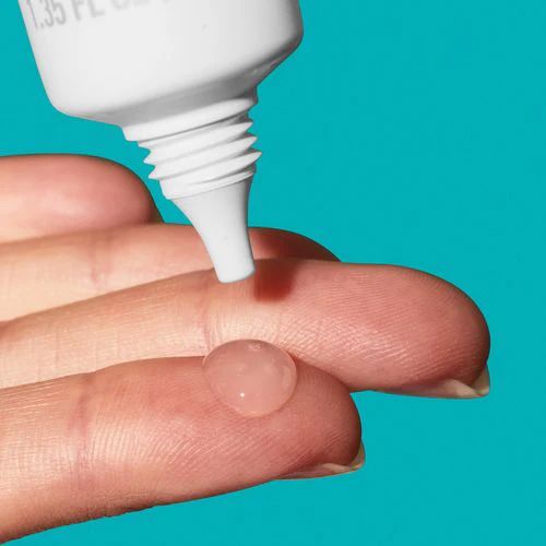 Hand applying a small amount of clear gel to the fingertip with a teal background.