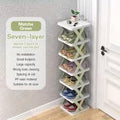 White shoe rack with multiple pairs of shoes on a wooden floor next to a door.