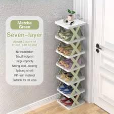 White shoe rack with multiple pairs of shoes on a wooden floor next to a door.
